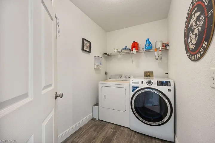Washroom with separate washer and dryer, a textured ceiling, and dark hardwood / wood-style floors