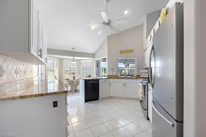 Kitchen with white cabinetry, kitchen peninsula, stainless steel appliances, and a wealth of natural light