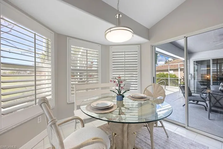 Tiled dining area featuring lofted ceiling