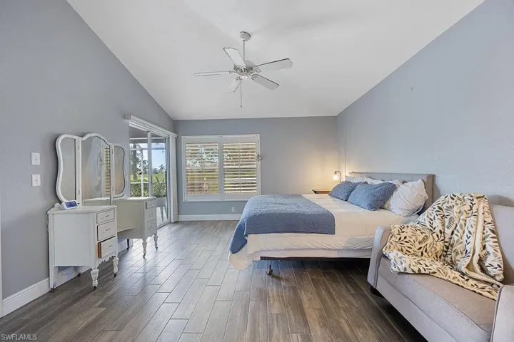 Bedroom featuring vaulted ceiling, ceiling fan, and dark hardwood / wood-style floors