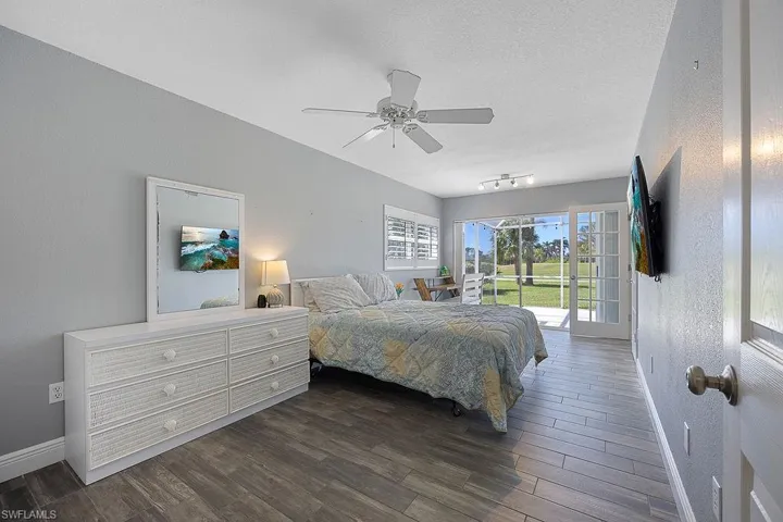 Bedroom with access to exterior, a textured ceiling, ceiling fan, and dark hardwood / wood-style floors
