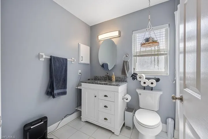 Bathroom featuring toilet, vanity, and tile patterned flooring