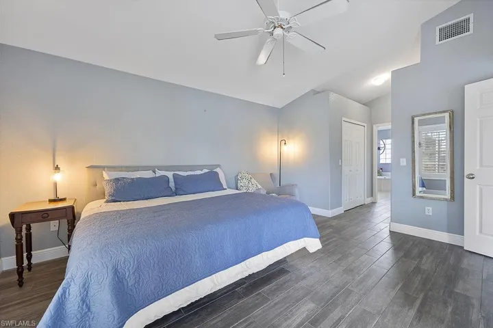 Bedroom with dark wood-type flooring, ceiling fan, lofted ceiling, and a closet