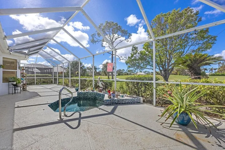 View of swimming pool with glass enclosure and a patio