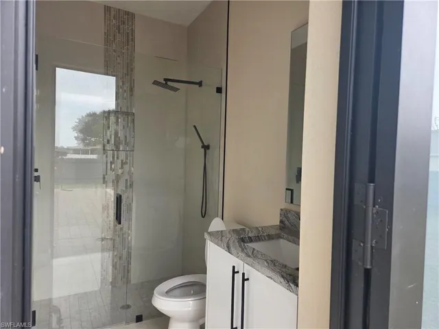 Full bathroom with vanity and a shower stall