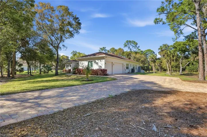 Long paver driveway, three-car garage and extra parking pad