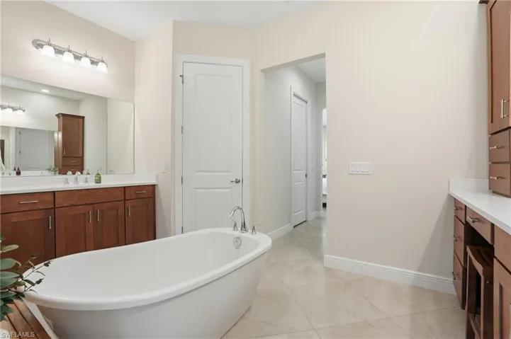 Full bathroom featuring vanity, a soaking tub, and private water closet