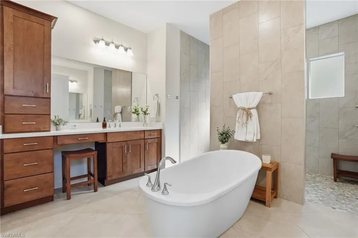Full bath with vanity, walk around shower, a soaking tub, and natural light