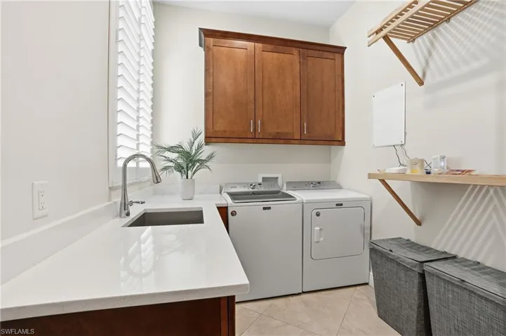 Doing laundry is a pleasure with amble countertop space, deep sink, and 42" upper cabinets