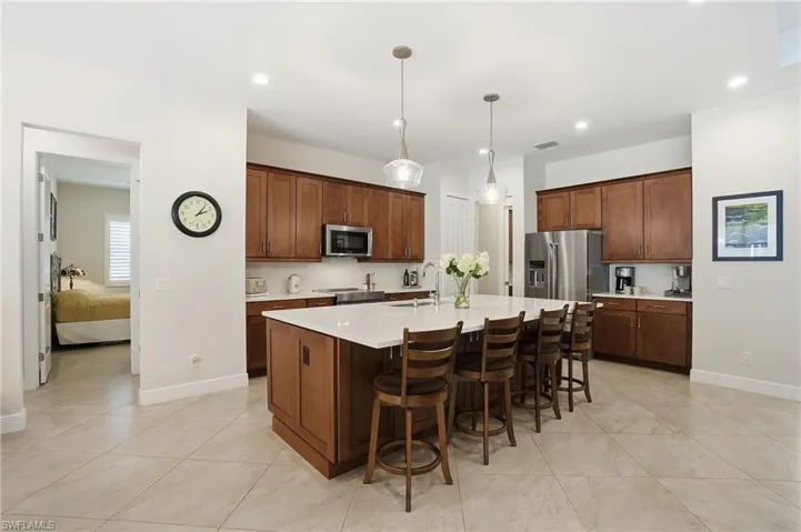 Kitchen featuring a kitchen bar, decorative light fixtures, an island with sink, appliances with stainless steel finishes, and recessed lighting