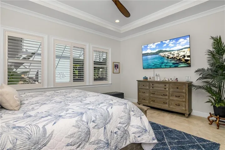 Master Bedroom with ornamental molding and ceiling fan, plantation shutters. Recessed lighting.