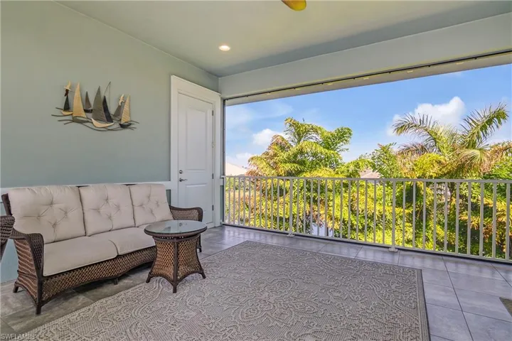 Another angle of the second floor balcony, note the bedroom door on the right. Water views beyond the trees.