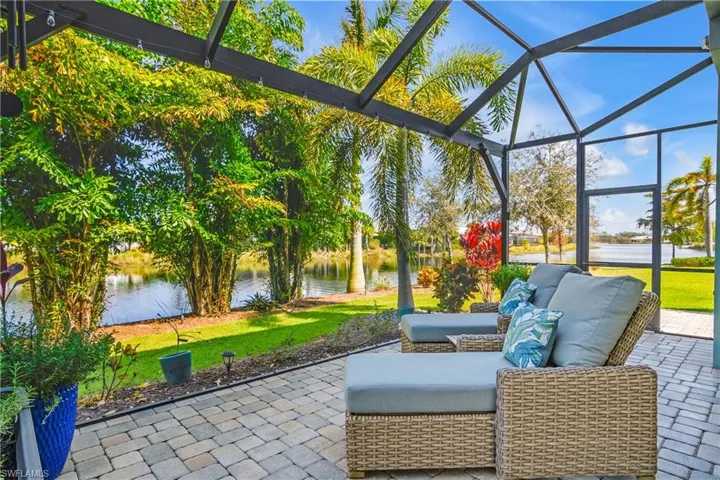 Peaceful views from the extended lanai / featuring outdoor lounge area, water views, and screened enclosure.