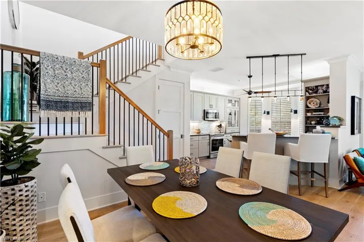 Dining space featuring crown molding, wood finished floors, a chandelier, and baseboards