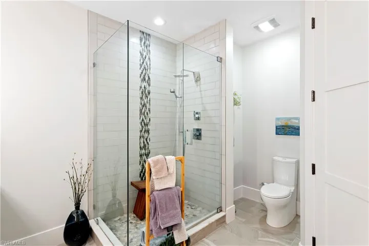 Full bath with a stall shower, double vanity, and tile patterned flooring