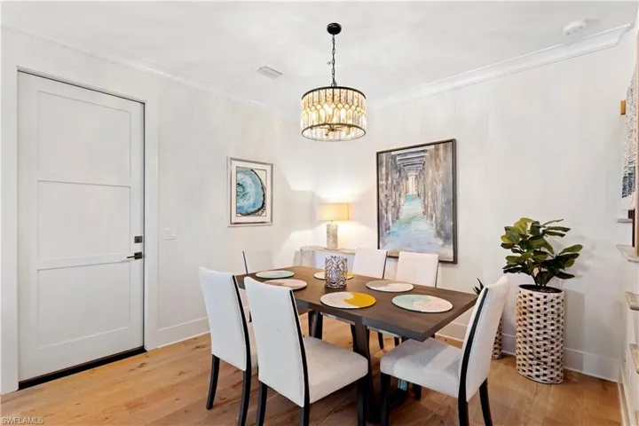 Dining space featuring stairway, light wood finished floors, and a chandelier