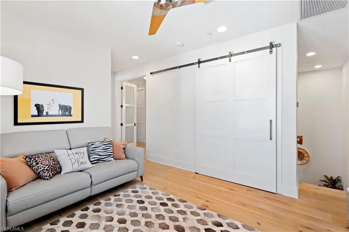Living area featuring light wood-type flooring, baseboards, healthy amount of natural light, a ceiling fan, and recessed lighting