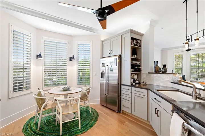 Kitchen featuring appliances with stainless steel finishes, dark countertops, backsplash, a sink, and open shelves