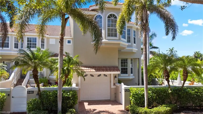 View of front of property featuring stucco siding, decorative driveway, a garage, a tile roof, and fence