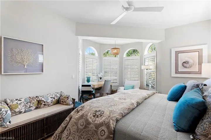 Bedroom featuring wood finished floors, a chandelier, baseboards, and a ceiling fan
