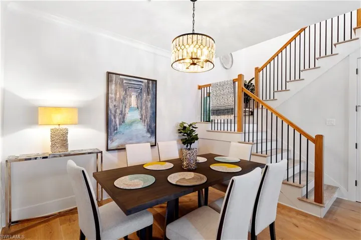 Living area with light wood finished floors, stairway, a ceiling fan, and ornamental molding
