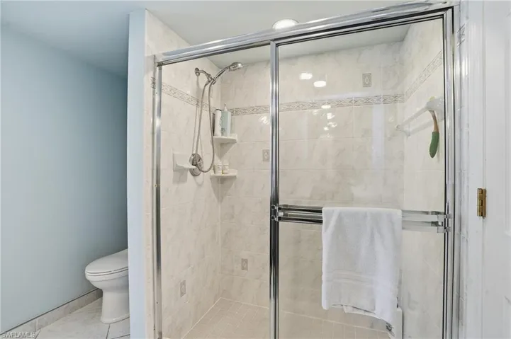 Bathroom featuring a shower stall and tile patterned flooring