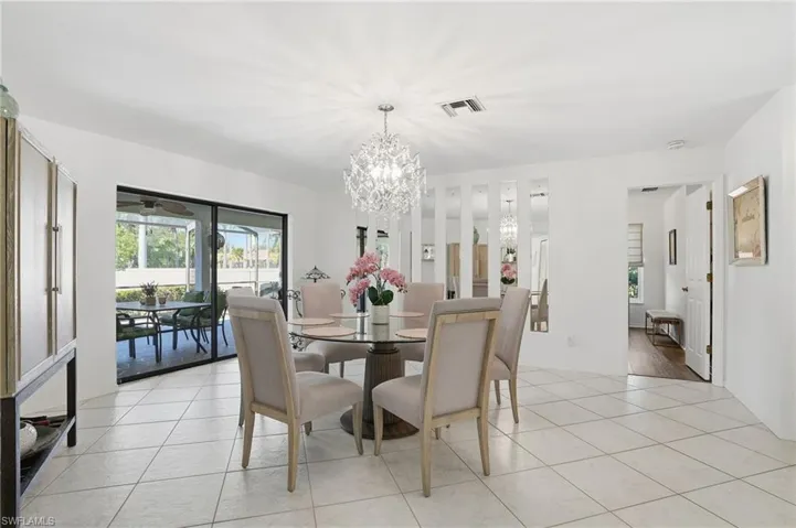 Dining space with light tile patterned floors and a chandelier