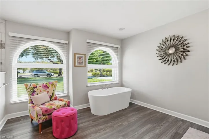 Full bath with a freestanding bath and wood finished floors