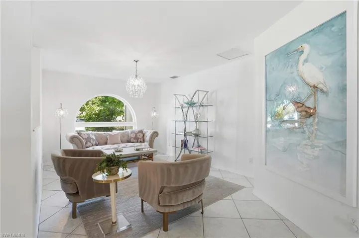 Sitting room with light floors and a chandelier.  This room could also be utilimzed a formal dining roo