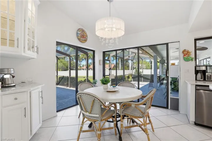 Dining space featuring healthy amount of natural light, light tile patterned floors, and a chandelier