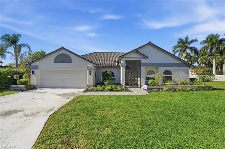 View of front of house featuring driveway, stucco siding, a garage, and a front lawn