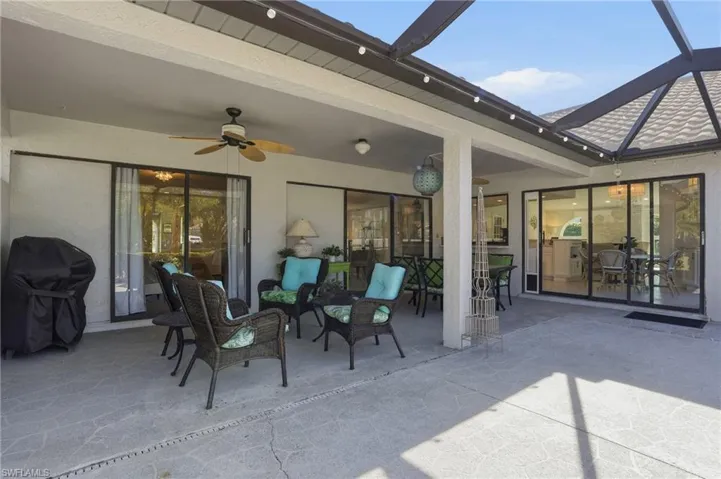 View of patio featuring a grill, a ceiling fan, a lanai, and outdoor dining area