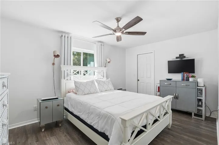 Bedroom with ceiling fan and dark wood-type flooring