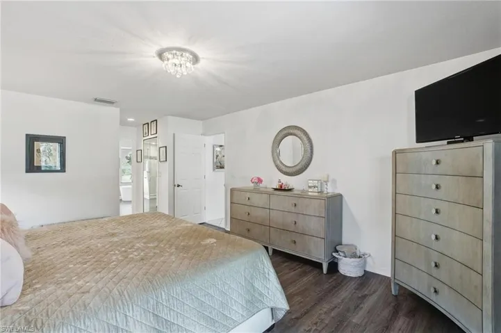 Bedroom with dark wood-style flooring, a chandelier, and recessed lighting