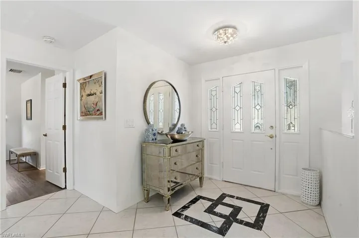 Foyer entrance with light tile patterned floors and inlaid floor details
