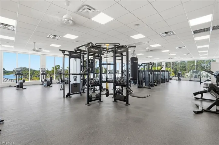 Workout area featuring a drop ceiling and a wall of windows