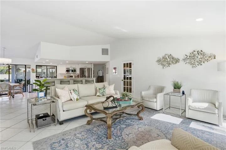 Living area with recessed lighting, vaulted ceiling, and light tile patterned flooring