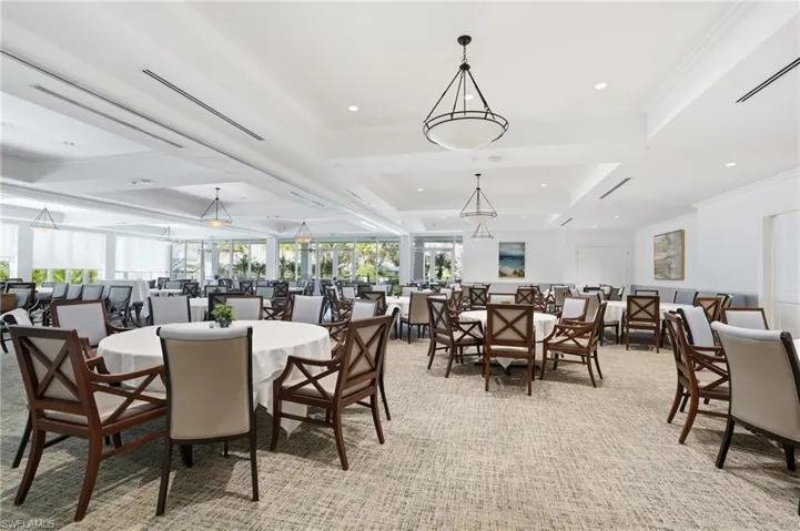 Dining room with crown molding, a tray ceiling, recessed lighting, and light carpet