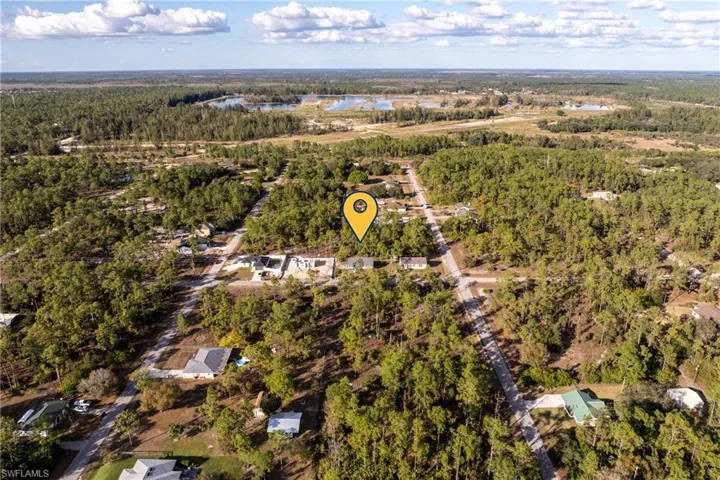 View of property location featuring a heavily wooded area and a nearby body of water