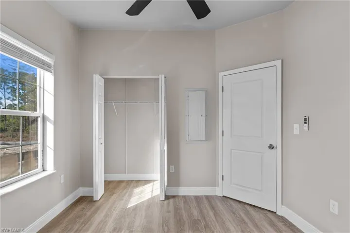 Unfurnished bedroom with a closet, light wood-style floors, and a ceiling fan