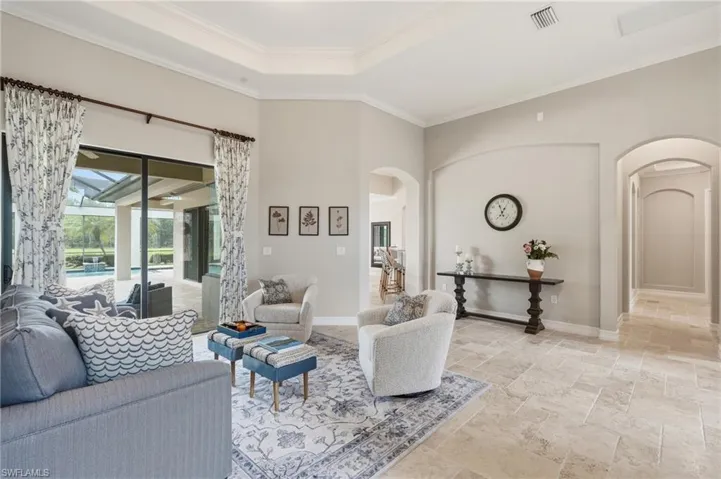 Open-concept living area with tray ceiling and recessed lighting