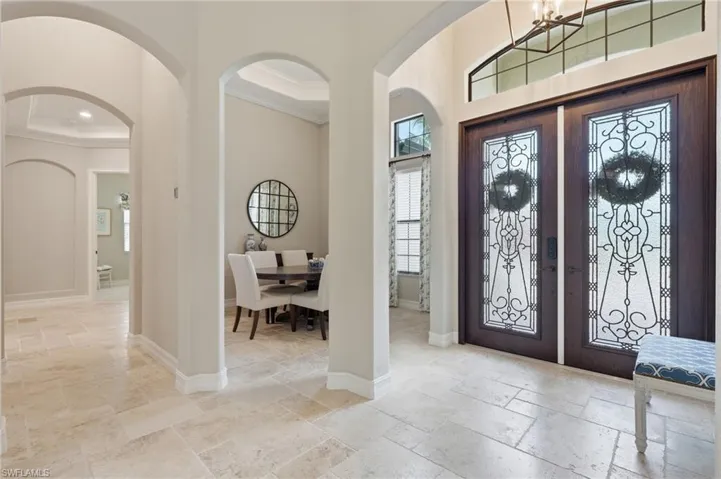 Grand entryway featuring double doors with decorative glass panels and transom window