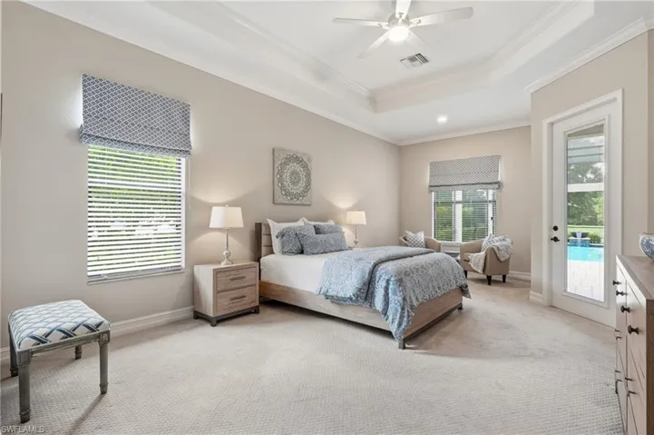 Spacious room featuring a tray ceiling, ceiling fan, and crown molding