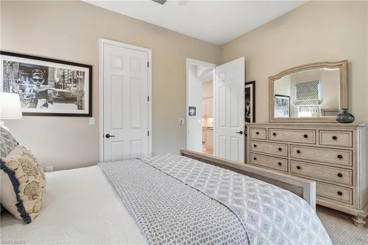 Recessed lighting illuminates the neutral-toned walls, enhancing the room's spacious feel