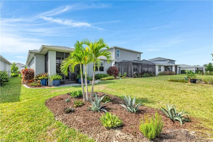 Rear view of property with a yard, a sunroom, stucco siding, and glass enclosure