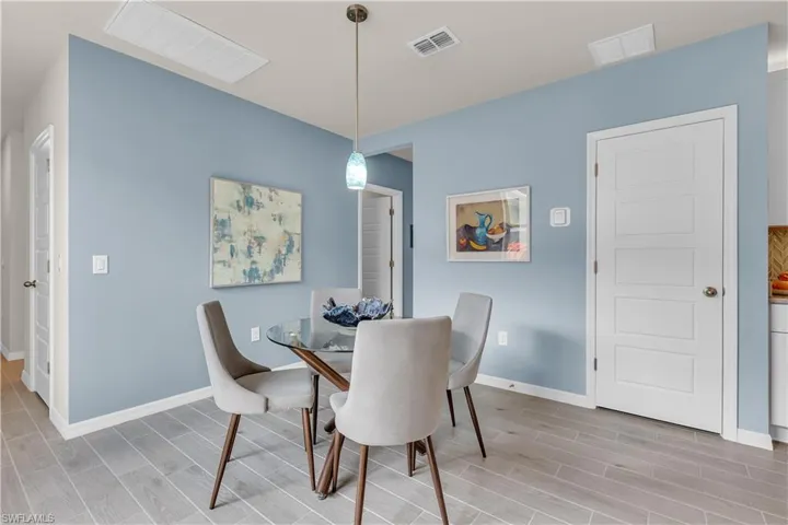 Dining space with wood look ceramic tiled floors and baseboards