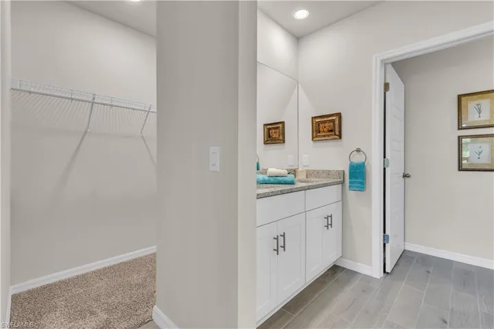 Master Bathroom with double vanity, separate stall for toilet, a walk in closet, Ceramic tile floors, and recessed lighting