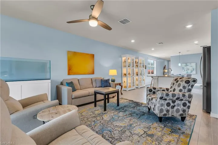 Living room with recessed lighting, ceiling fan, and light ceramic tile flooring