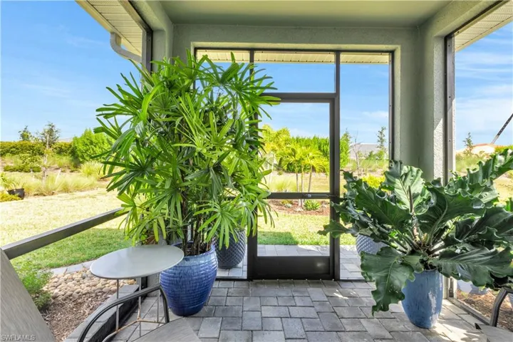 View of screened lanai to beautiful landscaped backyard