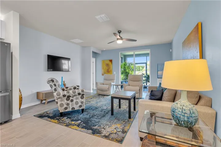 Living area with wood look tiled floors and a ceiling fan